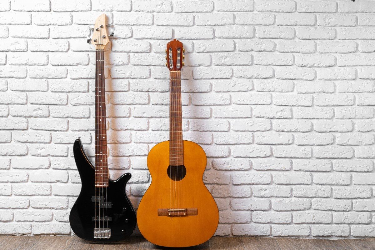 Set of guitars on the floor against white brick wall