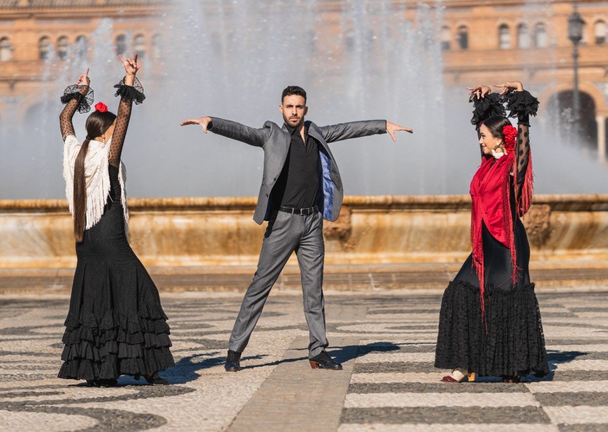 Three people dancing flamenco in a traditional square