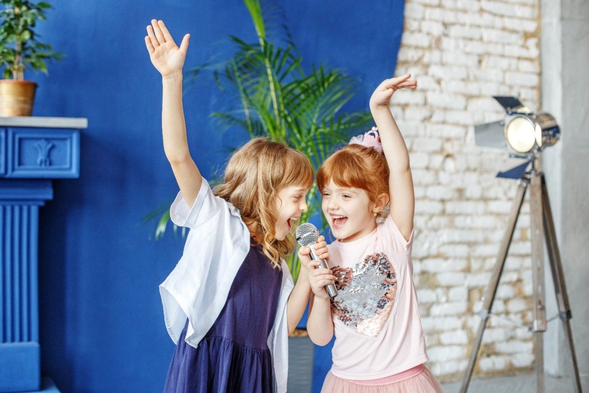 Two little funny children dance and sing a song together