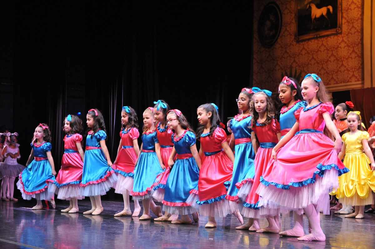 Little gitls on stage wearing colorful dresses