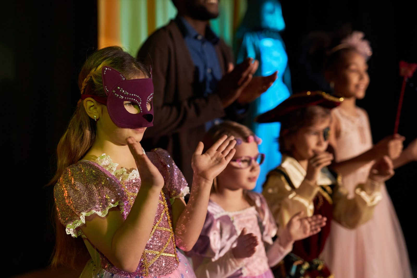 teen-girl-wearing-mask-and-costume-standing-on-stage