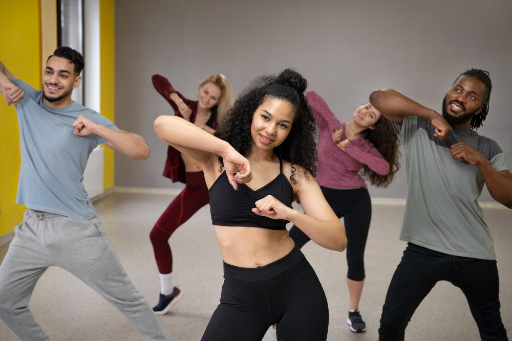 A dance group consisting of two males and three females practicisng in a studio