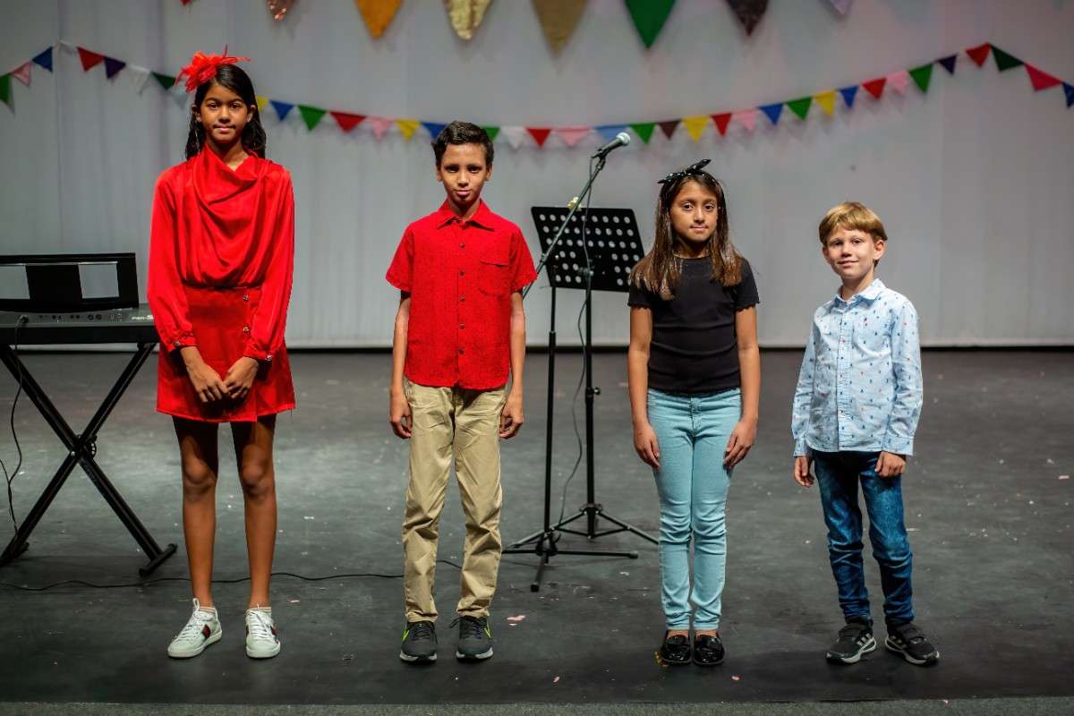 Four children of various ages on singing stage