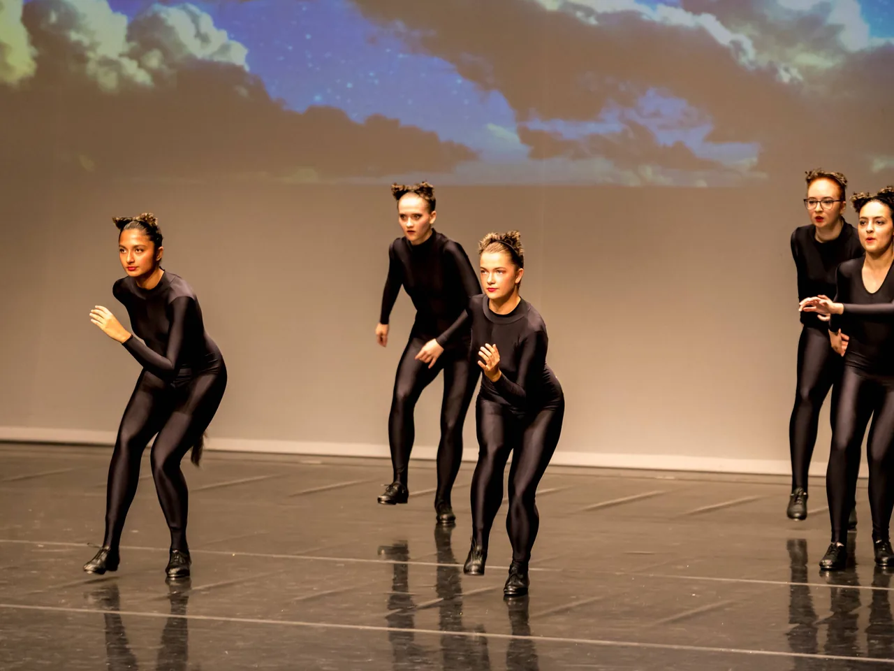 Modern dance students performing a group sequence on stage