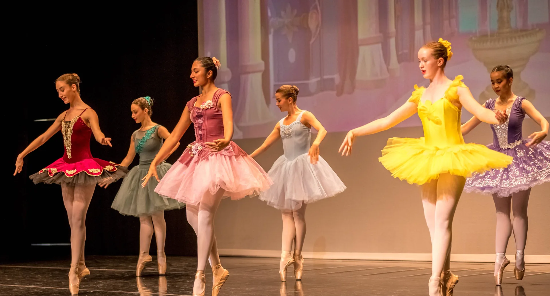 Ballet Centre students in costume performing together on stage at an end of year show
