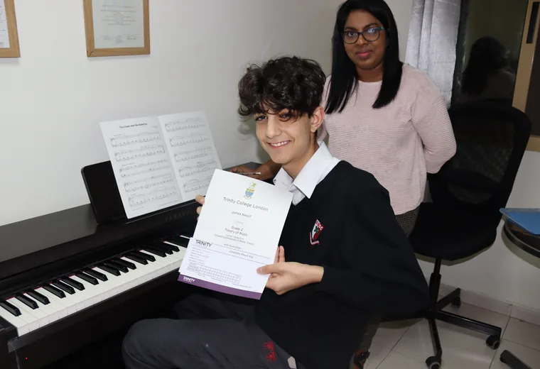 A keyboard student with their certificate