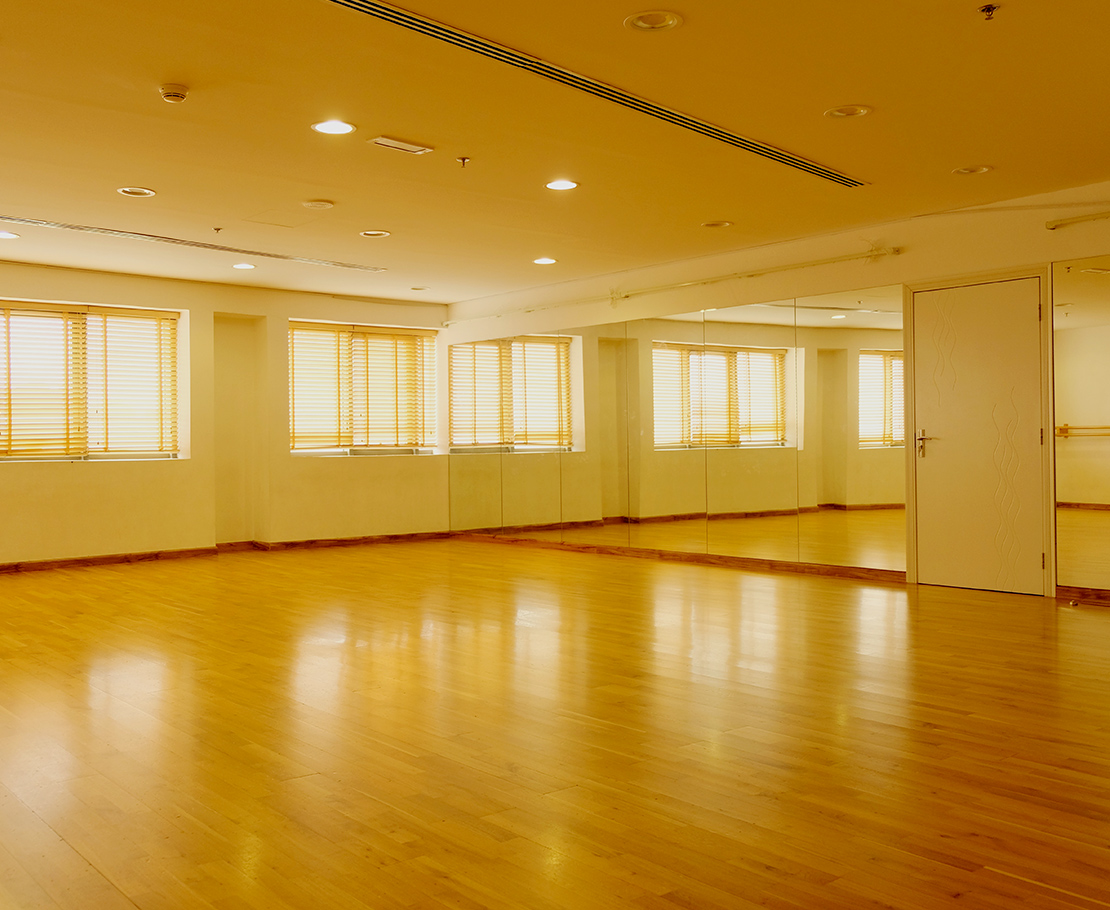 An empty ballet studio at the centre, sprung floor and barres