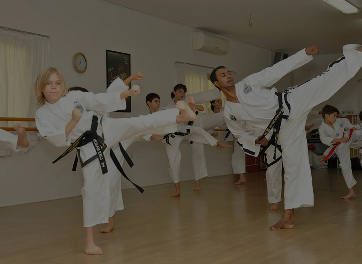 The taekwondo instructor leading a kicking drill with his students