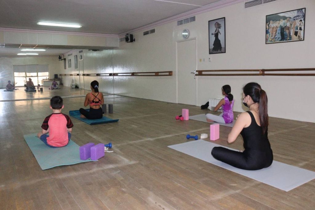 young students sitting in Yoga Class meditating