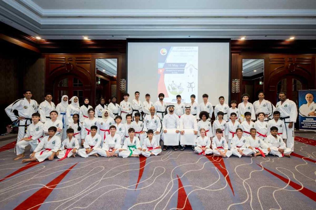 taekwondo group of students sitting and posing for photo