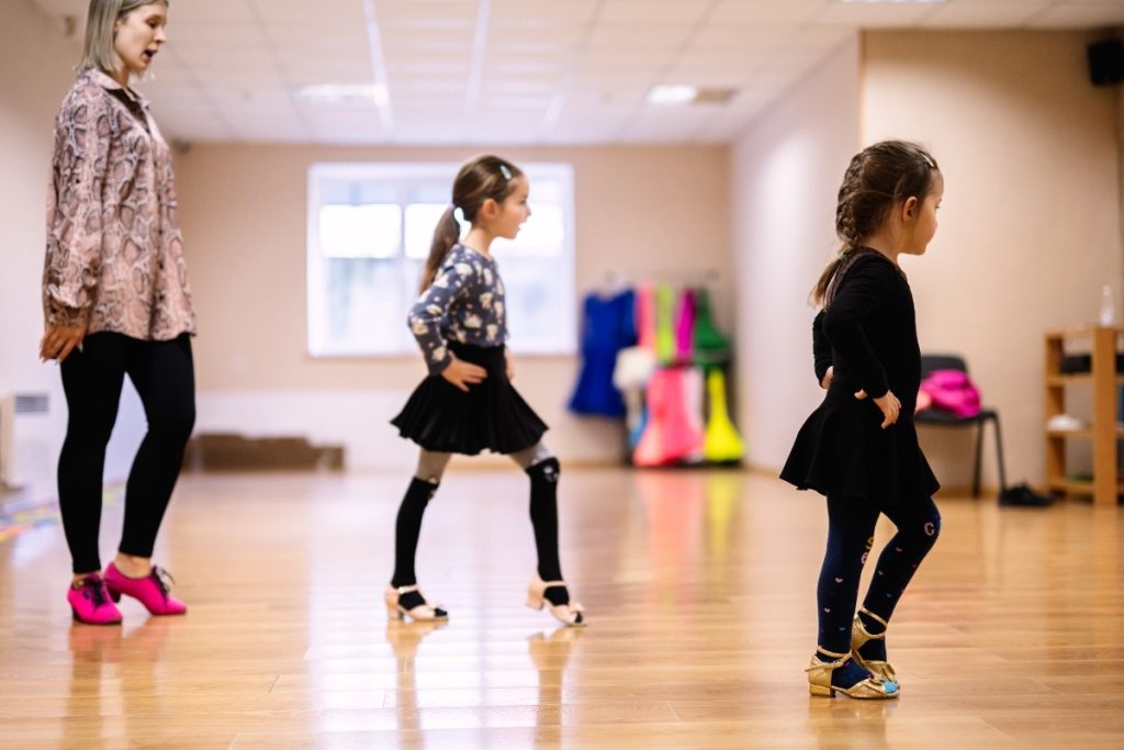 Young Girls Learning Dance Moves in Classroom with Instructor