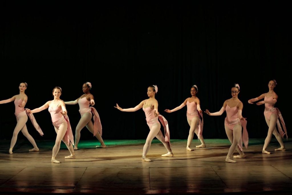 little girls in ballet attire performing on stage